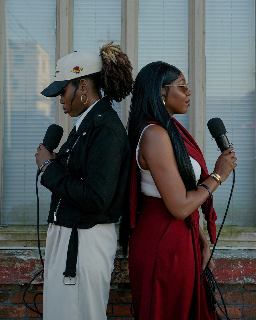 The women behind Nevertheless holding podcast microphones